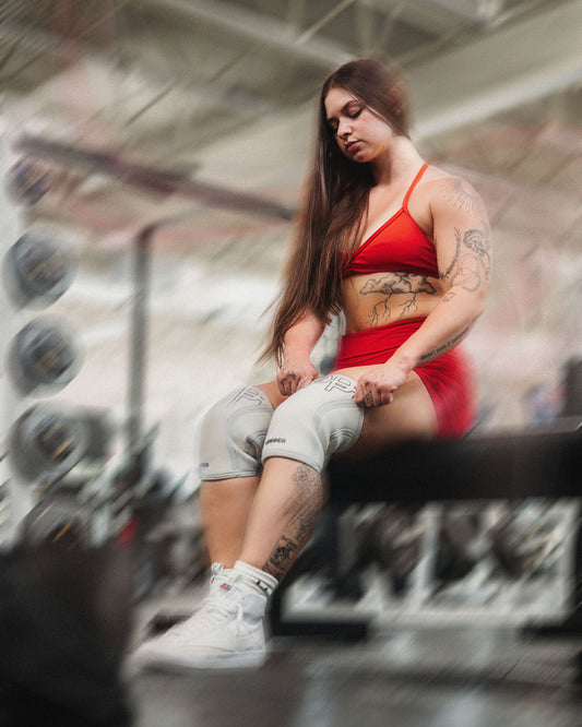 woman putting on knee sleeves